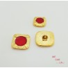 Botón de metal dorado con motivo rojo lacado